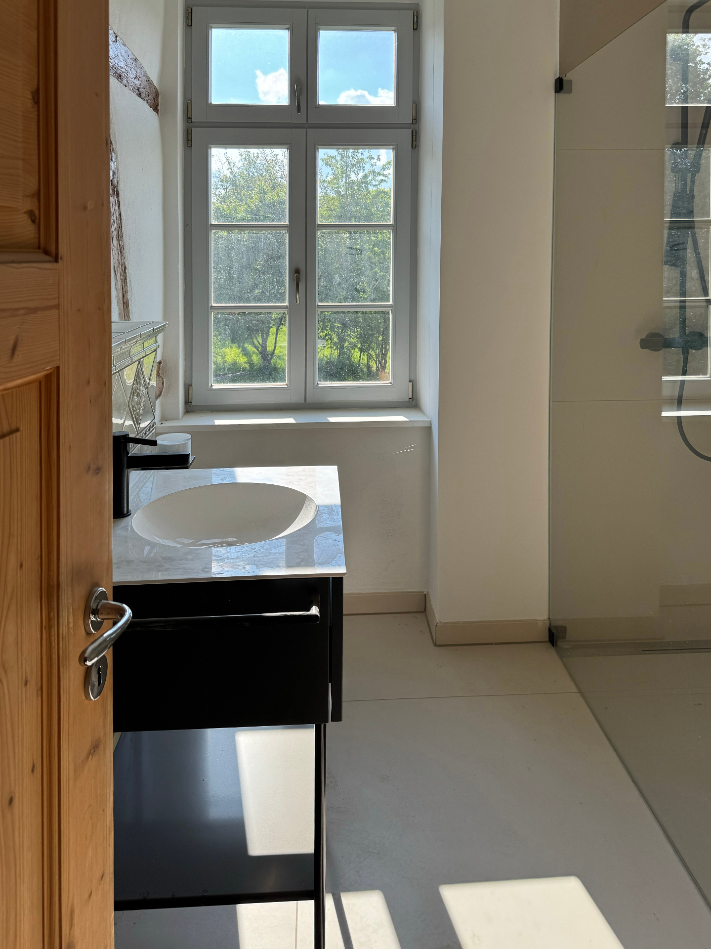 Bad mit großem Fenster, Dusche und Blick ins Grüne